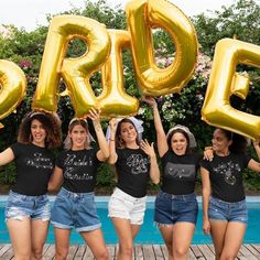 four women in black shirts holding up large gold balloons that spell out the word p & o