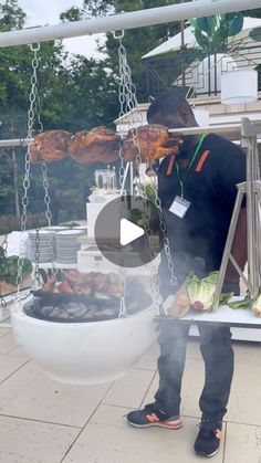 a man standing next to a grill on top of a white plate filled with food