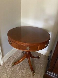 a small wooden table sitting on top of a carpeted floor next to a door