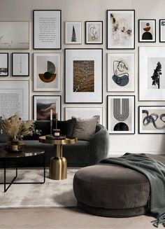 a living room with pictures on the wall and a couch in front of an ottoman