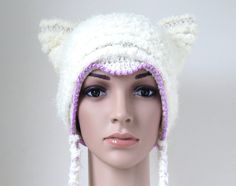 Women's cute and cuddly cat hat in white with attractive pink edging and long braided tassels. It's made with wonderfully soft vegan friendly yarn and is very warm and comfortable to wear. This kitty beanie would make a unique gift for all those cat loving ladies in our lives. Meow! Designed and lovingly handmade by me. Yarn: Very soft acrylic polyamide blend. This hat is also available in a wool blend: https://www.etsy.com/uk/listing/477960961/white-cat-hat-for-women-and-teen-girls?ref=shop_home_active_31 Size: Average size head (Approx. 22in./56cm head circumference) Care: Hand wash in cool water. Lay flat to dry.  Ready to ship. To see more cat hats and other animal hats, click here: https://www.etsy.com/uk/shop/MinnaMatildaDesigns?ref=l2-shopheader-name§ion_id=1915921 To see cowls and Cozy White Crochet Hat, Cozy Warm White Crochet Hat, Warm Cozy White Crochet Hat, Cute White Knitted Hat, Cozy White Handmade Hat, Cute White Handmade Crochet Hat, White Fitted Hand-knitted Hat, White Handmade Crochet Hat Fitted, Fitted White Hand Knitted Crochet Hat