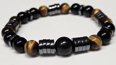 This bracelet features high quality 8mm Heishi Hematite, Black Obsidian, 10mm center Black Obsidian, and Tiger Eye beads, which are believed to be protective stones, and therefore nicknamed a triple protection bracelet. Please contact us if you would like a different bead size! We use strong NinjaCord for our stretch bracelets, which guaranteed not to break with normal use and normal activity.  Please note, that since we use genuine gemstones, there will be slight variations to the one pictured, Black Hematite Jewelry With 8mm Beads, Casual Black Stretch Bracelet With Gemstone Beads, Casual Black Jewelry For Healing, Spiritual Black Hematite Beaded Bracelets, Black Natural Stones Stretch Bracelet For Healing, Black Stretch Bracelet With Natural Stones For Healing, Adjustable Black Hematite Stretch Bracelet, Black Adjustable Hematite Stretch Bracelet, Healing Black Stretch Bracelet With Natural Stones