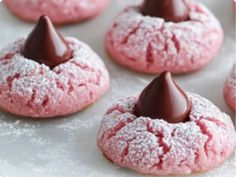 some pink cookies with chocolate frosting and sprinkles