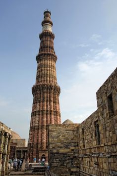 a tall tower with a clock on it's side in the middle of an old city