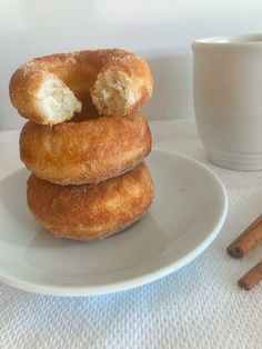 three doughnuts stacked on top of each other with cinnamon sticks next to them