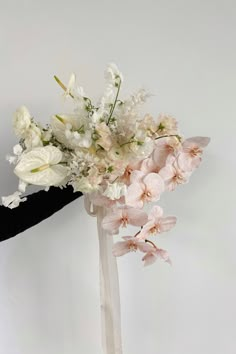 a woman holding a bouquet of flowers in her hand with white and pink colors on it