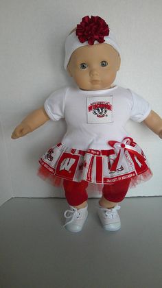 a baby doll wearing a white shirt and red skirt