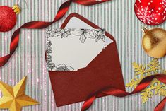 an envelope with a christmas ornament on it and other decorations around it,