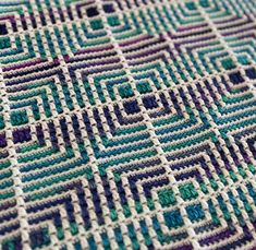 a close up view of a crocheted blanket with squares and lines on it