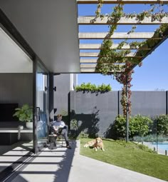 a man sitting on a bench next to a dog under a pergolated roof