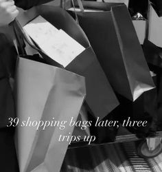 black and white photograph of shopping bags with text reading 29 shopping bags later, three trips up