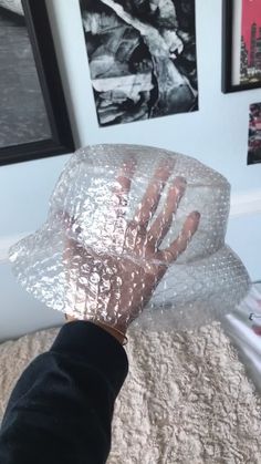 a person's hand is wrapped in plastic on top of a bed with pictures