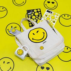 a white bag sitting on top of a yellow table covered in smiley face stickers