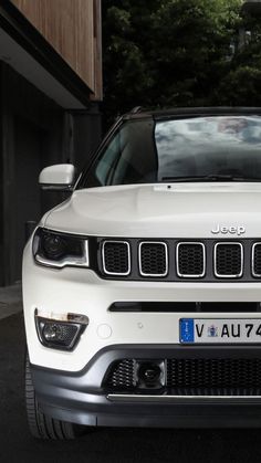 a white jeep parked in front of a building