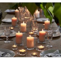 a table set with candles and place settings