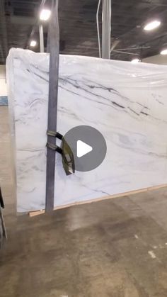 a large white marble slab being worked on in a warehouse or building with video recording