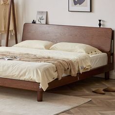 a bed sitting on top of a hard wood floor next to a wall mounted clock