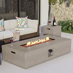 a fire pit sitting on top of a white tile floor next to a couch and table