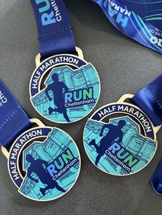 three marathon medals with blue ribbons around them