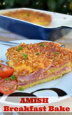 ham and cheese breakfast bake on a white plate with tomatoes, tomato slices and bread crumbs