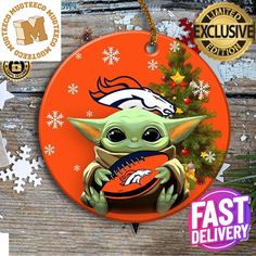 the baby yoda ornament is holding an orange football