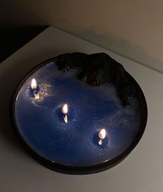 a plate with candles floating in it on a table