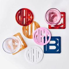 four monogrammed coasters with different shapes and sizes on white background, including one for each letter