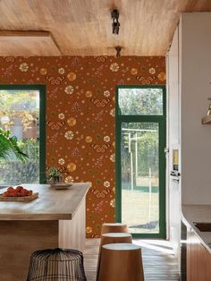 the kitchen is decorated with orange and green wallpaper