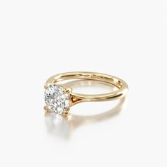 a yellow gold engagement ring with a single diamond in the center, on a white background