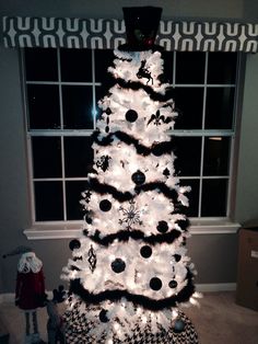 a white christmas tree decorated with black and white ornaments