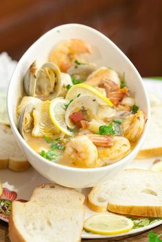 a white bowl filled with seafood and bread