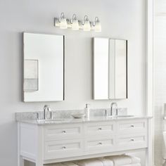 a white bathroom with two sinks and mirrors