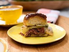 a close up of a sandwich on a plate with a cup of tea in the background