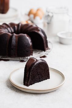 a chocolate bunt cake on a plate with one slice missing