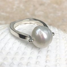 14KT white gold + genuine Paspaley South Sea Pearl Ring. Fashion quality Paspaley pearl. Paspaley Pearls are considered to be the finest South Sea pearls available. Sizing can be customized for an additional charge. Features a modern, European shank band which levels out the ring so there is no slipping and sliding aro Timeless Silver Pearl Ring With Polished Finish, Silver Pearl Ring With Polished Finish, Modern White Gold Akoya Pearl Jewelry, Modern White Gold Jewelry With Akoya Pearl, Modern Pearl Ring For Formal Occasions, Modern Pearl Rings For Anniversary, White Sterling Silver Pearl Ring With Polished Finish, White Pearl Ring With Polished Sterling Silver, White Polished Pearl Ring