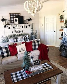 a living room decorated for christmas with black and white plaid pillows on the couches