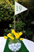 a vase filled with yellow tulips sitting on top of a white table cloth