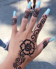 a woman's hand with hendix and flowers on it, painted blue