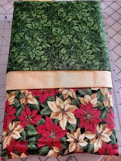 three different types of fabric are laid out on top of each other, one is green and the other has red poinsettia leaves