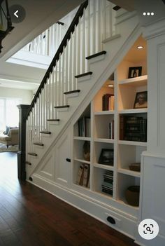 an open staircase with bookshelves under the stairs