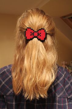 a woman with long blonde hair wearing a red and black bowknote clip