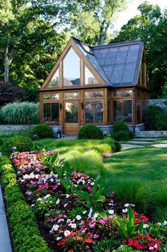 the house is surrounded by lush green grass and flowers