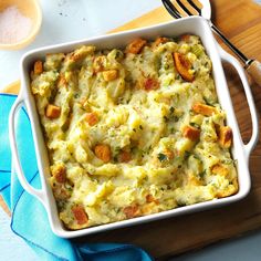 a casserole dish with potatoes and carrots in it on a cutting board