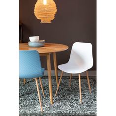 a dining room table with two chairs and a bowl on top of it in front of a brown wall