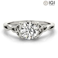 a white gold engagement ring with an intricate knot around the band and a round diamond center stone