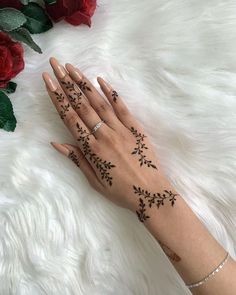 a woman's hand with hendix on it and flowers in the background