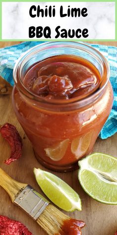 chili lime bbq sauce in a glass jar next to two limes and a brush