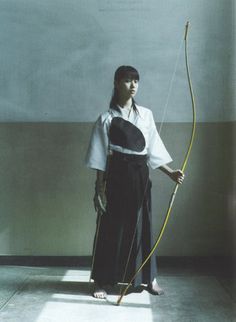 a woman standing with a bow and arrow in her hand