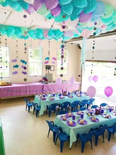 a room filled with lots of tables covered in blue and purple decorations