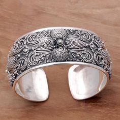 This spectacularly detailed bracelet features an intricate symmetrical floral pattern created with minute silver dots and swirls against an oxidized backdrop. Cahya Krisna crafts the cuff as a fresh and breathtaking example of Balinese sterling silver artistry. Luxury Traditional Cuff Bracelet With Intricate Design, Luxury Metal Cuff Bracelet With Jubilee Design, Luxury Silver Cuff Bracelet In Fine Jewelry Style, Cheap Silver Cuff Bracelet With Jubilee Style, Luxury Classic Cuff Bracelet With Intricate Design, Luxury Sterling Silver Fusion Jewelry, Floral Cuff, Wide Cuff Bracelets, Silver Chain Bracelet